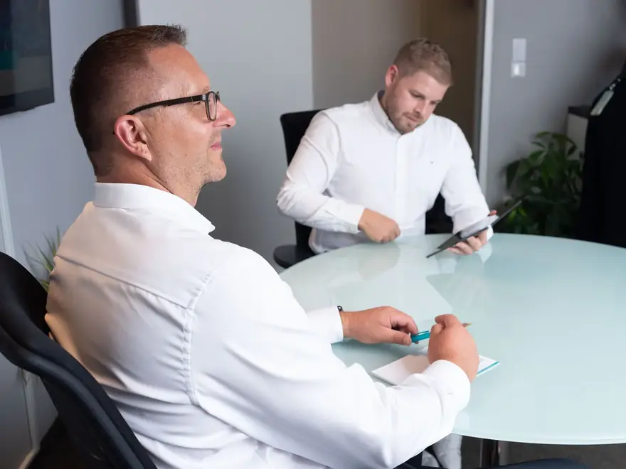 Zwei Berater von CMD im Gespräch am Besprechungstisch